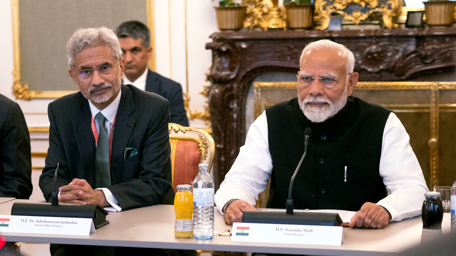 Dr. S. Jaishankar seated beside Prime Minister Narendra Modi at a conference table; nameplates read External Affairs Minister and Prime Minister