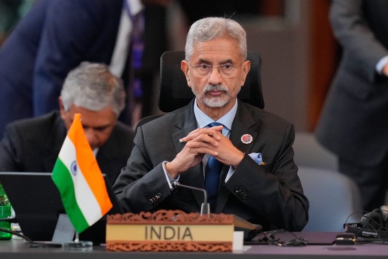 Dr. S. Jaishankar seated with hands clasped behind a nameplate reading India at a multilateral meeting