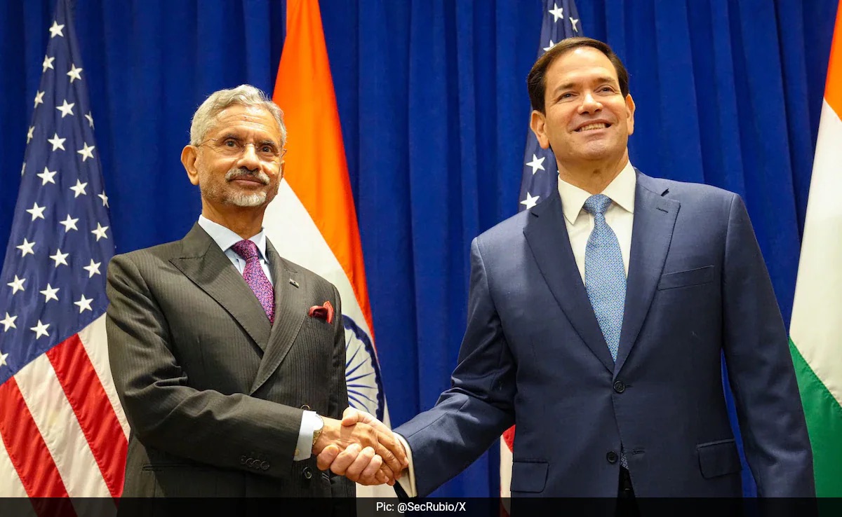 Dr. S. Jaishankar shaking hands with US Secretary of State Marco Rubio in front of Indian and US flags