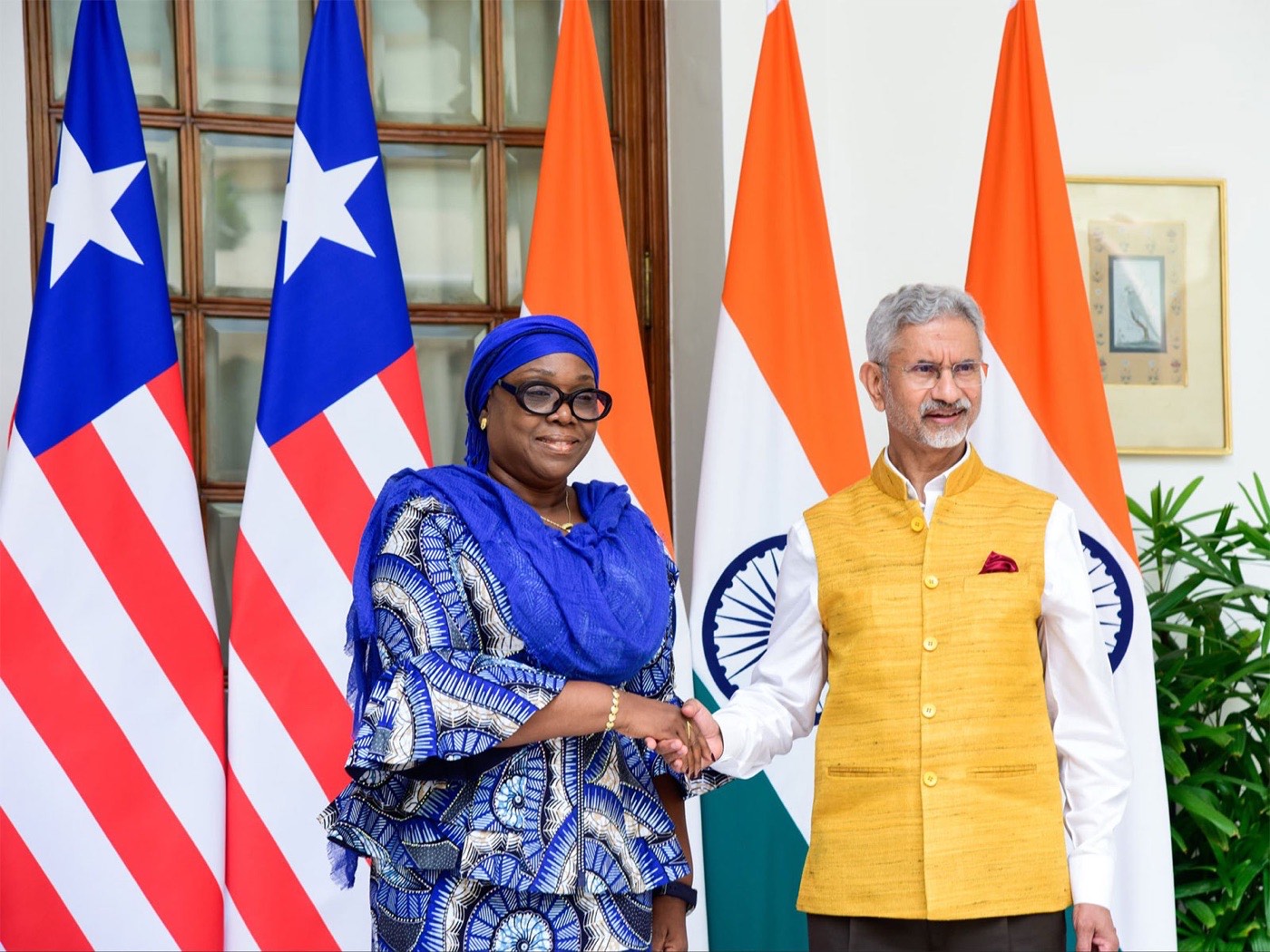 Dr. S. Jaishankar in a yellow Nehru jacket shaking hands with Liberia’s foreign minister in front of Liberian and Indian flags