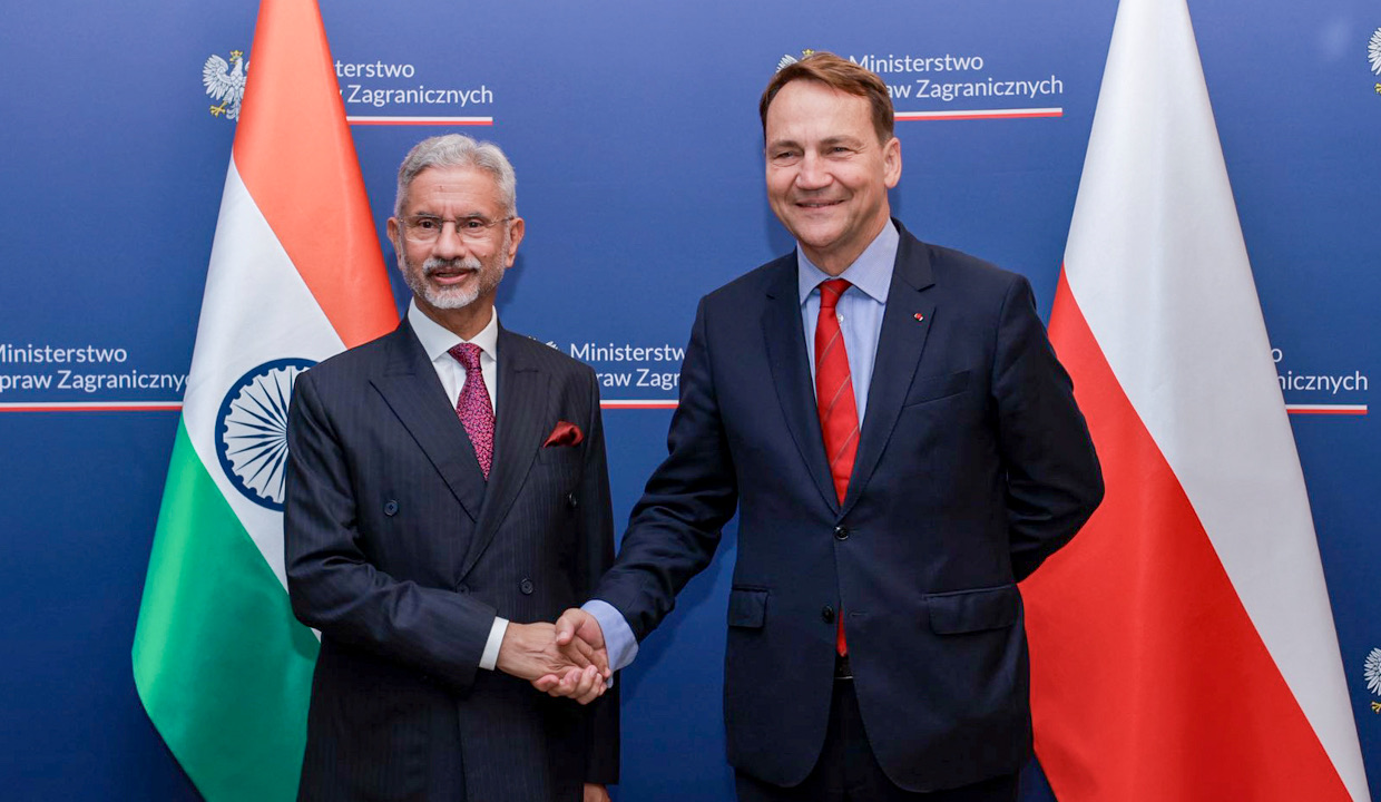 Dr. S. Jaishankar shaking hands with Poland’s foreign minister in front of Indian and Polish flags and a Polish Foreign Ministry backdrop