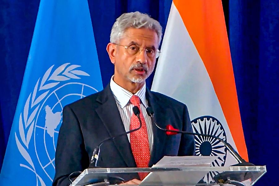 Dr. S. Jaishankar speaking at a lectern between the United Nations flag and the Indian flag