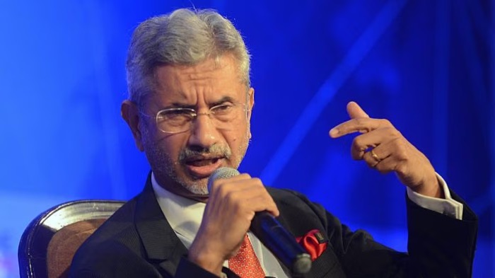 Dr. S. Jaishankar speaking into a handheld microphone and gesturing during a seated discussion